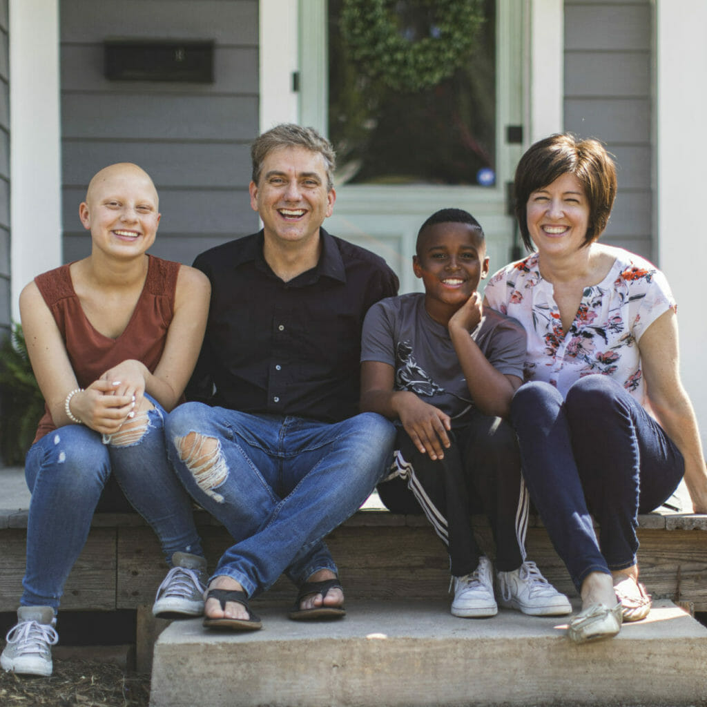 family of 4 poses on steps